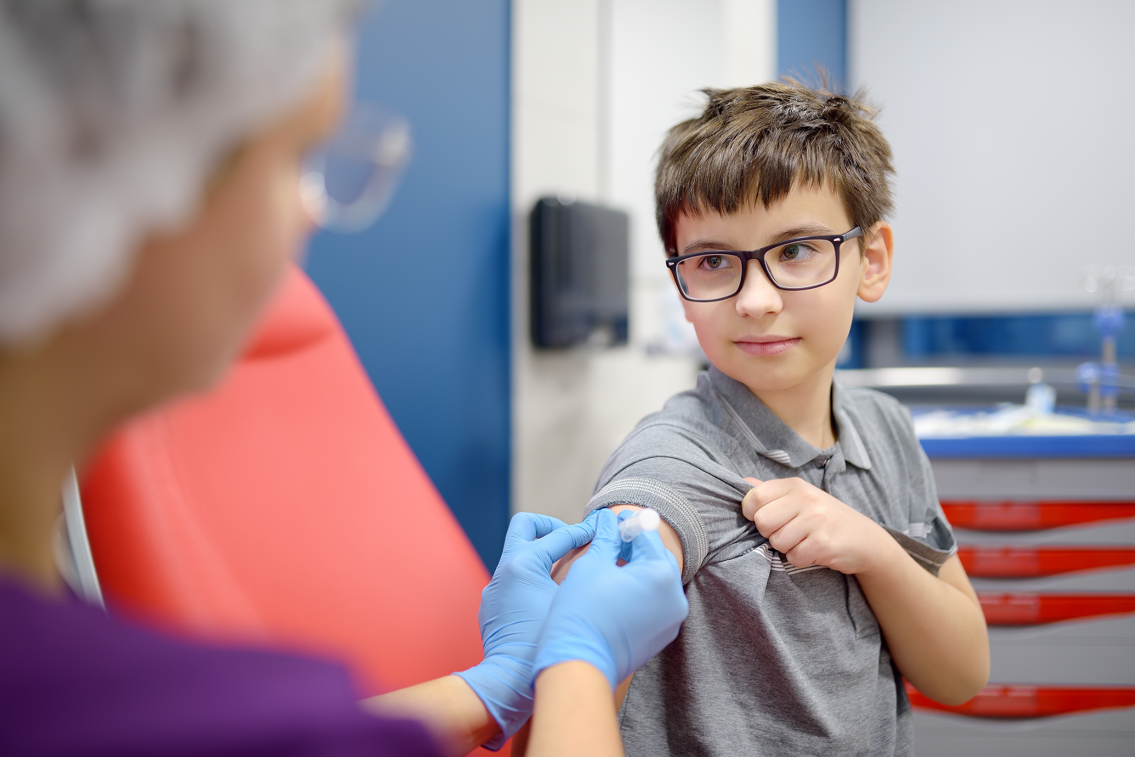 Young boy looking happy about to receive a vaccine