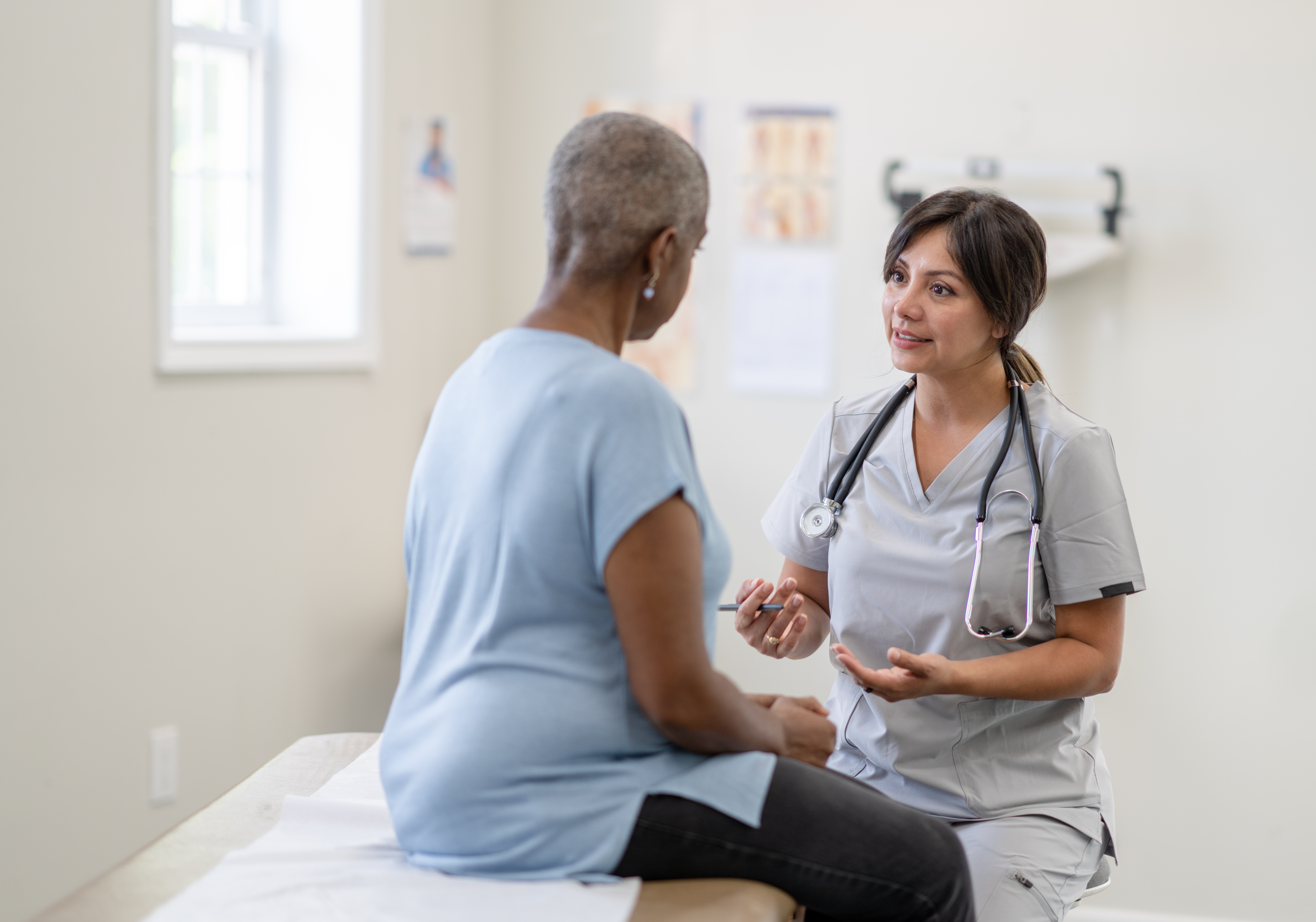 Doctor speaking to middle-aged woman experiencing menopause